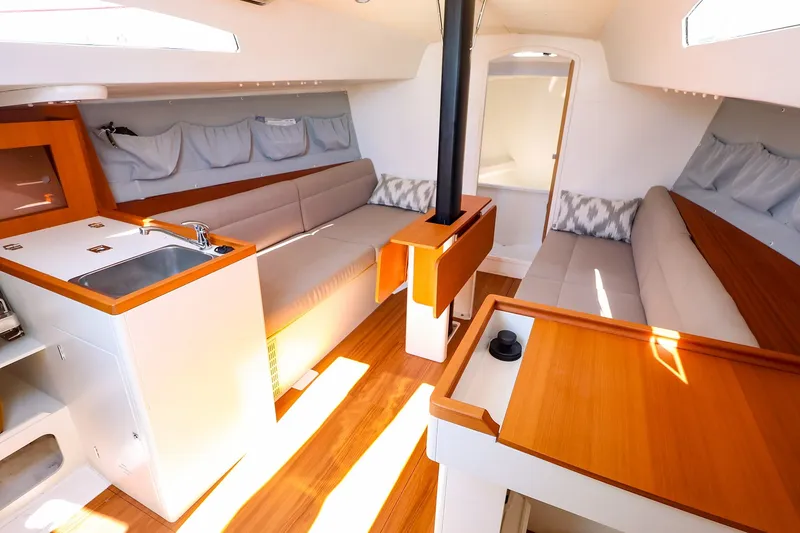 Slide: The Image of 2023 J Boats J/99 interior with modern seating, kitchenette, and wood accents. - 37
