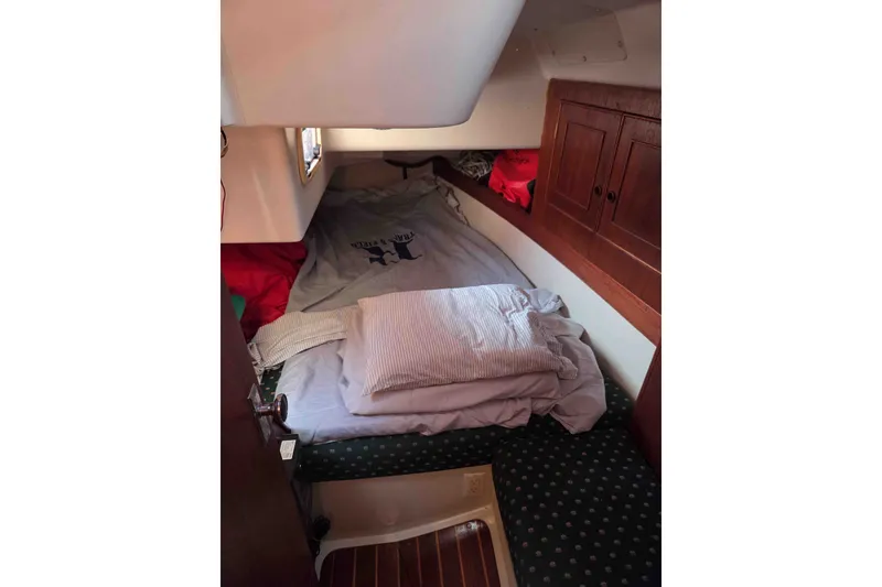 Slide: The Image of Cozy cabin interior of 1990 Canadian Sailcraft 34 sailboat with bedding and wooden cabinetry. - 14