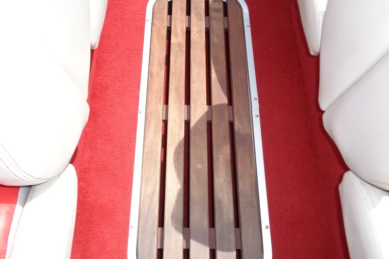 Slide: The Image of Red carpeted interior of a 1989 Stingray 172 SC boat with wooden flooring. - 21