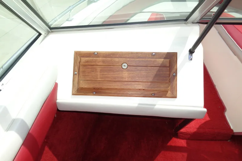 Slide: The Image of Interior of 1989 Stingray 172 SC boat with wooden compartment and red carpet. - 13