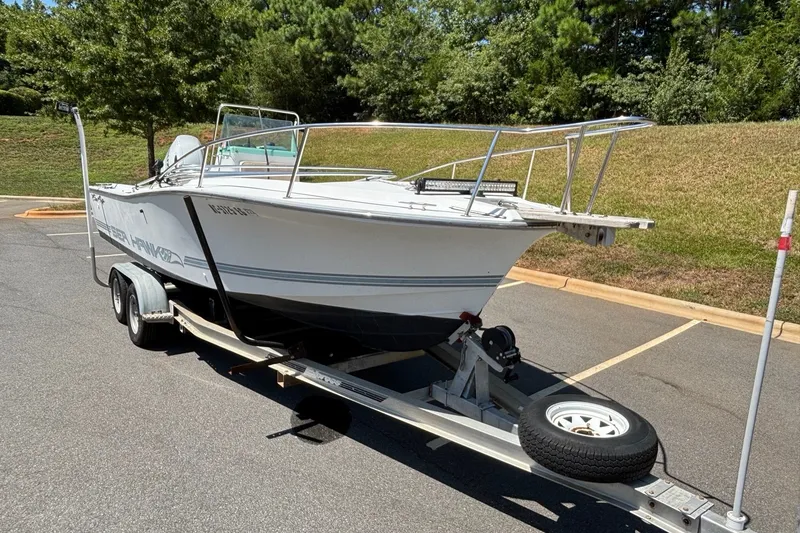 Slide: The Image of 1989 Chris-Craft 213 Sea Hawk boat on trailer in parking lot, sunny day. - 13