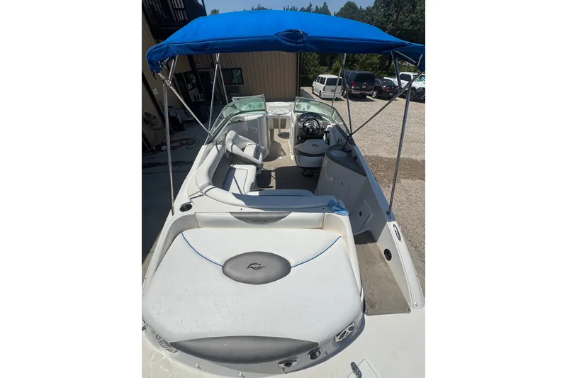Slide: The Image of 2009 Rinker 248 Captiva Deckboat with blue canopy, spacious seating, and modern design. - 16