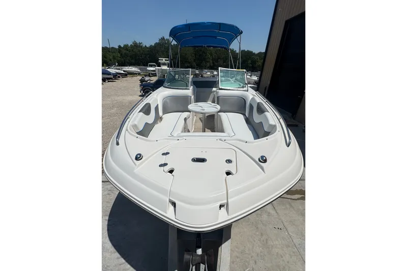 Slide: The Image of 2009 Rinker 248 Captiva Deckboat with blue canopy, docked outdoors. - 3
