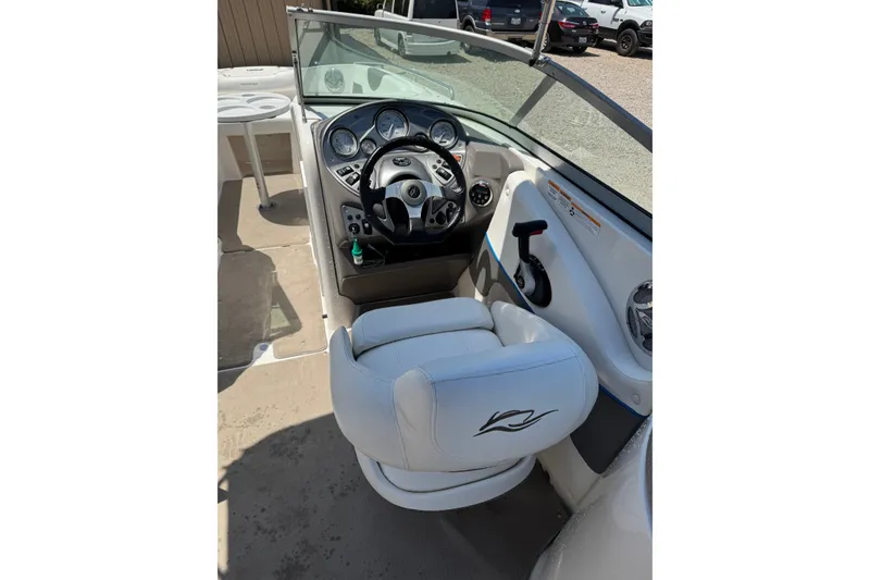 Slide: The Image of 2009 Rinker 248 Captiva Deckboat cockpit with steering wheel and white captain's chair. - 8