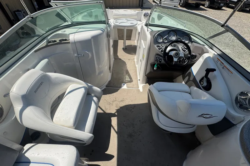 Slide: The Image of 2009 Rinker 248 Captiva Deckboat interior with white seating and modern dashboard controls. - 7