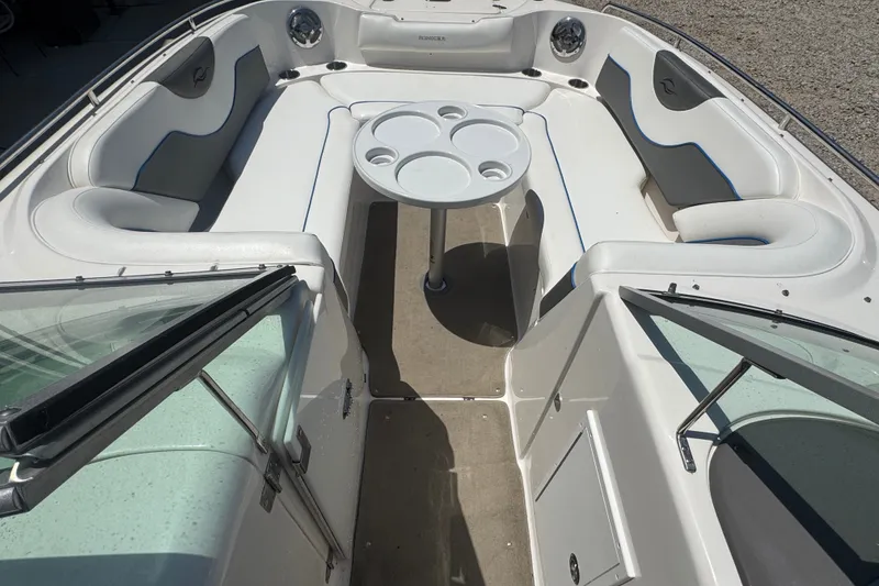 Slide: The Image of 2009 Rinker 248 Captiva Deckboat interior with seating and table, showcasing spacious design. - 6