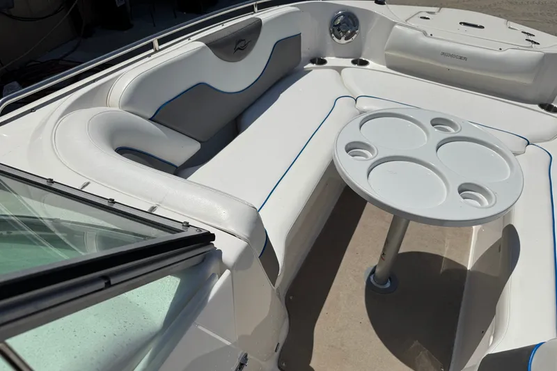 Slide: The Image of 2009 Rinker 248 Captiva Deckboat interior with seating and round table. - 12
