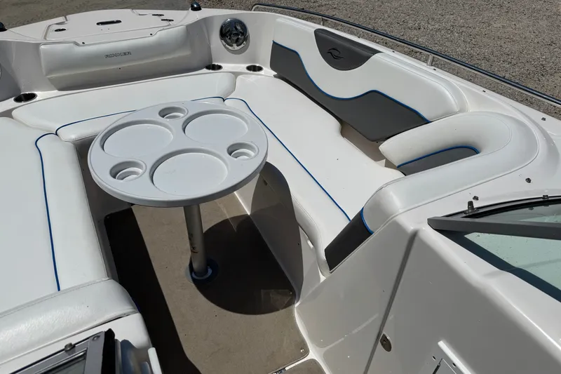 Slide: The Image of 2009 Rinker 248 Captiva Deckboat interior with white seating and round table. - 11