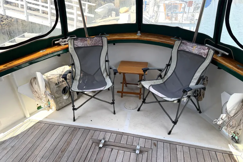 Slide: The Image of Two folding chairs and a small table on a 1974 Willard/Vega Voyager boat deck. - 21