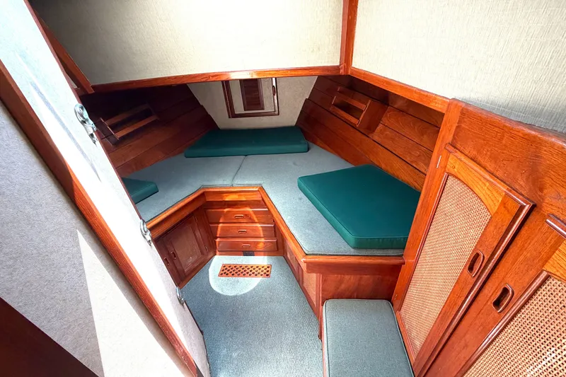 Slide: The Image of 1974 Willard Vega Voyager cabin interior with wooden finish and green cushions. - 19