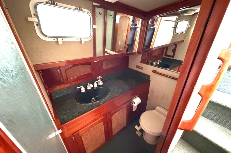 Slide: The Image of 1974 Willard Vega Voyager boat bathroom with wooden cabinetry and porthole window. - 16