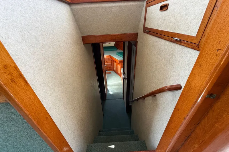 Slide: The Image of Interior staircase of a 1974 Willard Vega Voyager boat, featuring wooden accents and carpeted steps. - 14