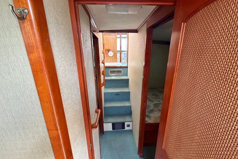 Slide: The Image of Interior hallway of a 1974 Willard Vega Voyager boat with wooden accents and carpeted stairs. - 15