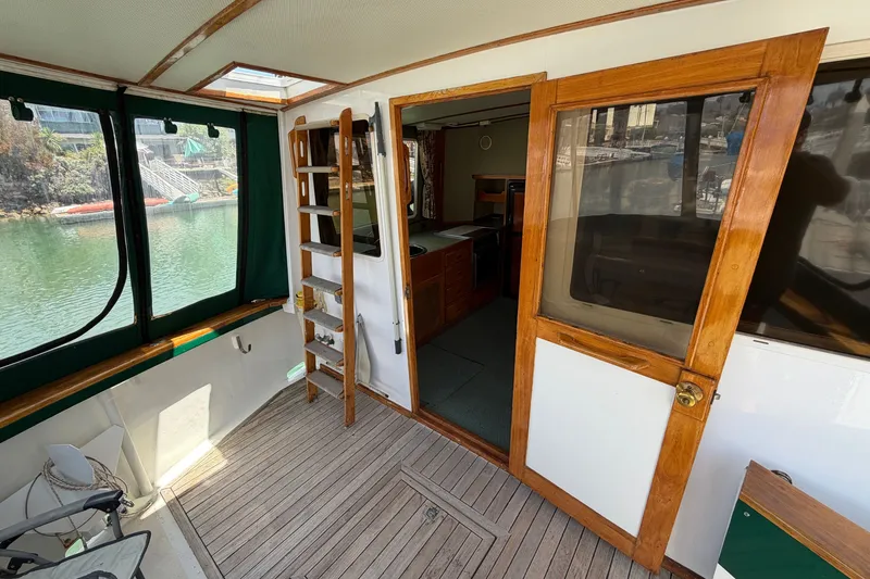 Slide: The Image of 1974 Willard Vega Voyager boat interior with wooden door and ladder, overlooking water. - 22