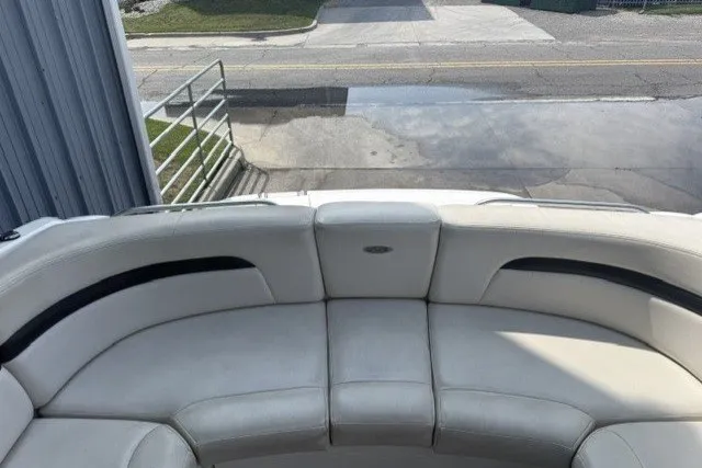 Slide: The Image of 2003 Chaparral 265 SSi boat interior with white leather seating, docked near a road. - 14