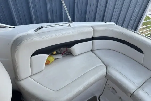 Slide: The Image of 2003 Chaparral 265 SSi boat interior with white cushioned seating and storage compartment. - 13