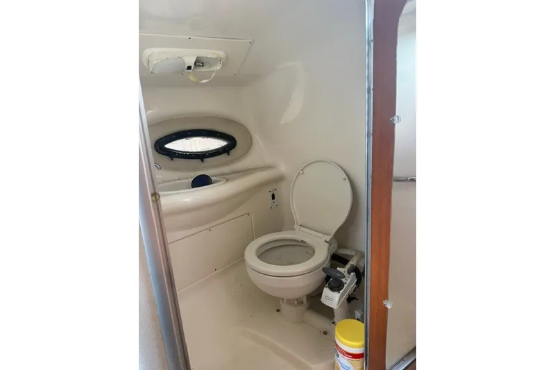 Slide: The Image of 2003 Chaparral 265 SSi boat bathroom interior with toilet and porthole window. - 6