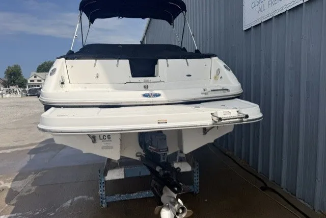 Slide: The Image of 2003 Chaparral 265 SSi boat, rear view, docked near a metal building. - 4