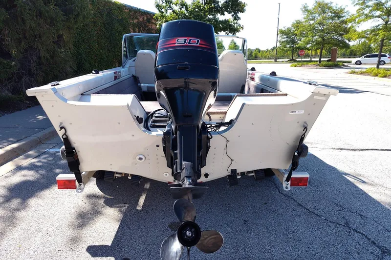 Slide: The Image of 1996 Smoker Craft Phantom 16 boat with 90 HP outboard motor, parked on street. - 16
