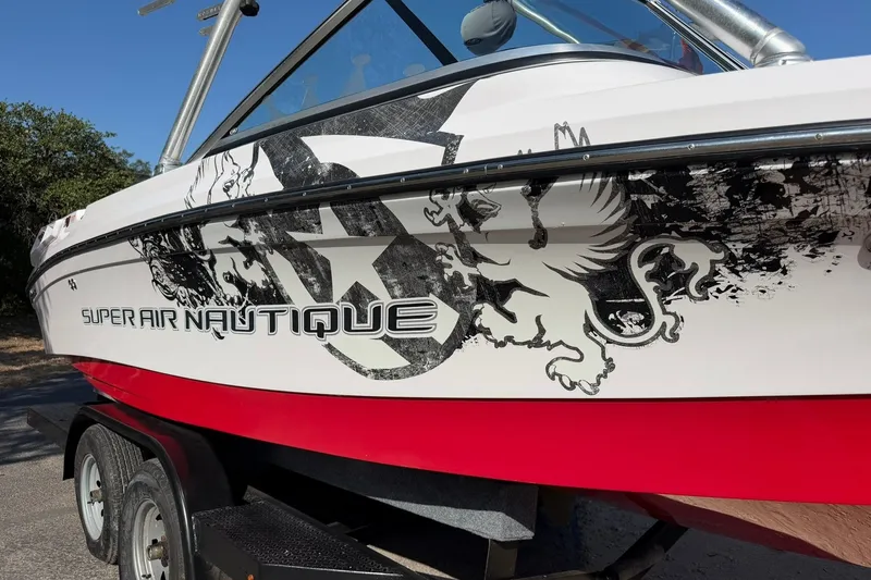 Slide: The Image of 2008 Correct Craft Super Air Nautique 210 with bold graphics on trailer. - 9