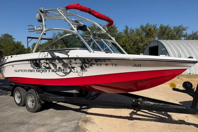 Slide: The Image of 2008 Correct Craft Super Air Nautique 210 boat on trailer, red and white design. - 8