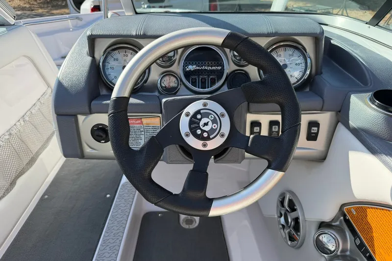 Slide: The Image of 2008 Correct Craft Super Air Nautique 210 dashboard with steering wheel and gauges. - 35