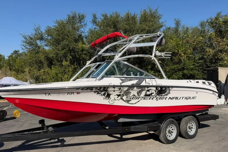 Slide: The Image of 2008 Correct Craft Super Air Nautique 210 boat on trailer, red and white design. - 2