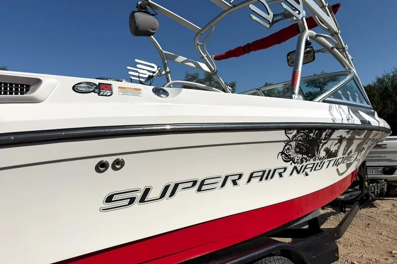Slide: The Image of 2008 Correct Craft Super Air Nautique 210 boat with red and white design. - 10