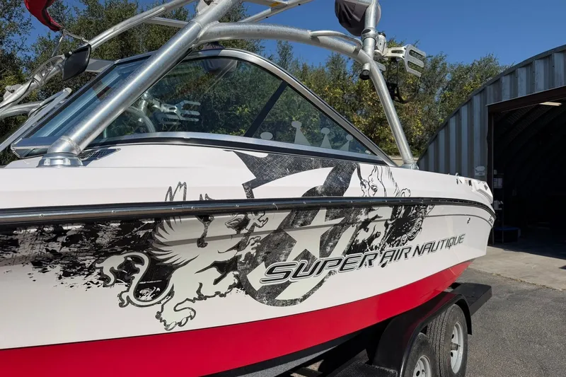 Slide: The Image of 2008 Correct Craft Super Air Nautique 210 boat with custom graphics on a trailer. - 16