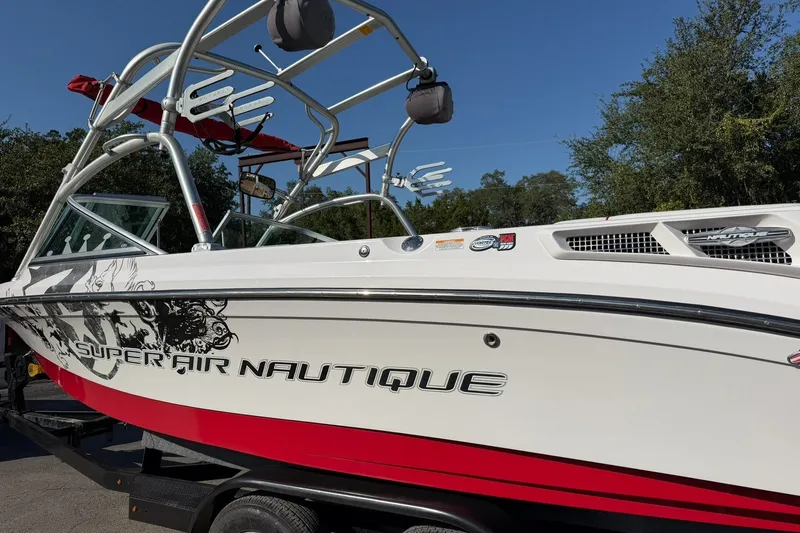 Slide: The Image of 2008 Correct Craft Super Air Nautique 210 boat with red and white design. - 17