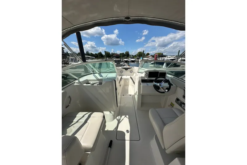 Slide: The Image of 2024 Sailfish 226 DC boat interior with helm, seating, and clear skies above. - 7