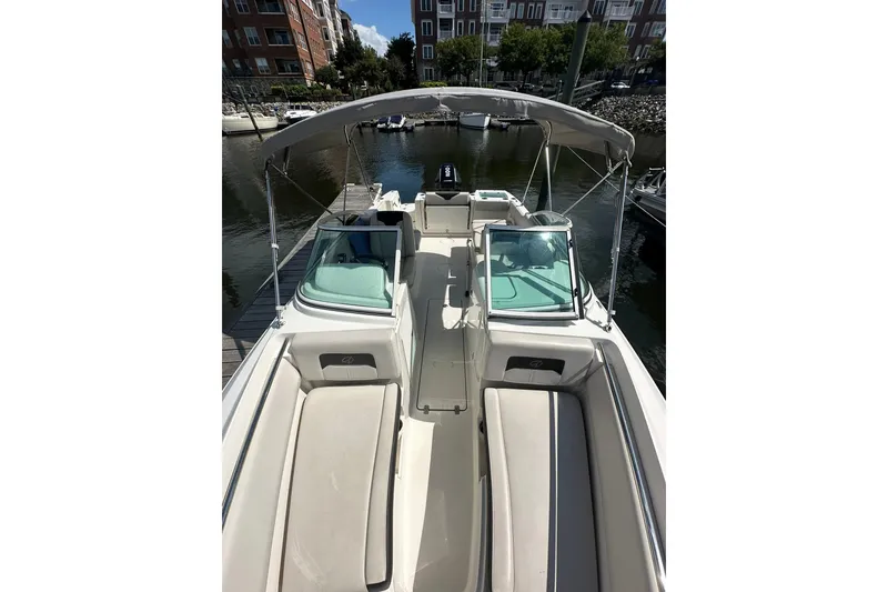 Slide: The Image of 2024 Sailfish 226 DC boat docked, featuring spacious seating and canopy. - 4