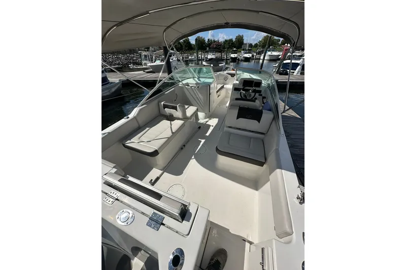Slide: The Image of 2024 Sailfish 226 DC boat interior with seating and helm, docked at marina. - 5