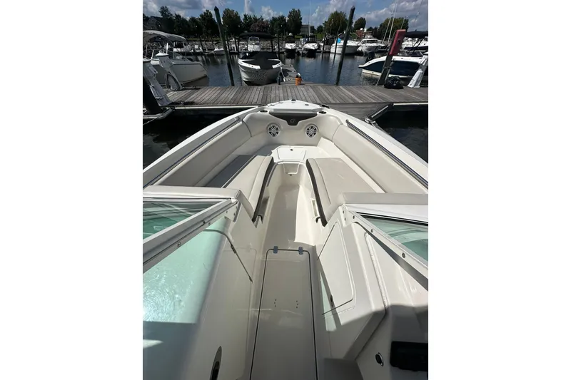 Slide: The Image of 2024 Sailfish 226 DC boat interior at marina, showcasing seating and docked boats. - 9