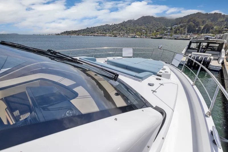 Slide: The Image of Die Cruisers Yachts 57 Fly von 2026 liegt am Dock mit Blick auf eine malerische Küstenlandschaft. - 17