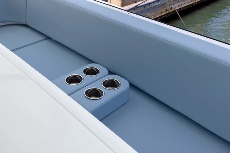 Slide: The Image of Die Cruisers Yachts 57 Fly von 2026 zeigt eine elegante blaue Sitzbank mit integrierten Getränkehaltern. - 14