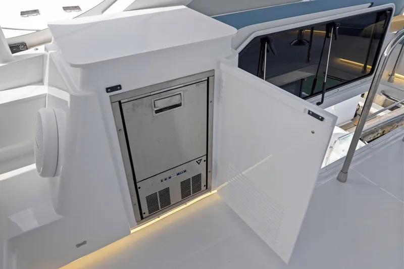 Slide: The Image of Die Cruisers Yachts 57 Fly von 2026 zeigt eine moderne Außenküche mit Kühlschrank und Stauraum. - 35