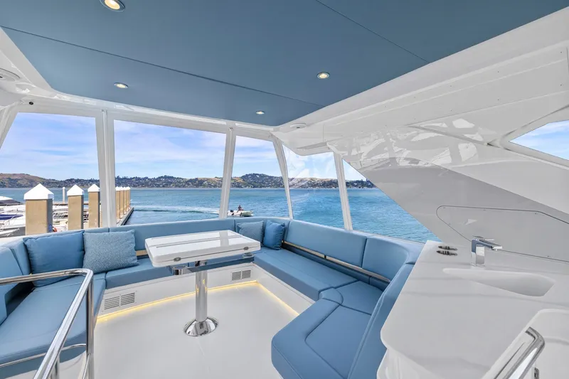 Slide: The Image of Das Bild zeigt das luxuriöse Deck einer Cruisers Yachts 57 Fly von 2026 mit blauen Polstern und einem Tisch. - 32