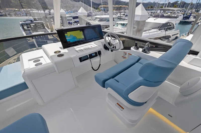Slide: The Image of Das Cockpit einer Cruisers Yachts 57 Fly von 2026 mit modernem Steuerstand und blauem Sitz. - 25