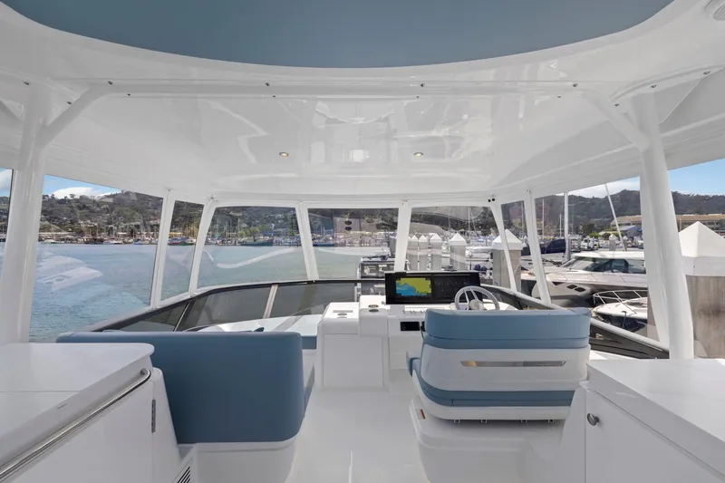Slide: The Image of Das Cockpit einer modernen Yacht mit blau-weißen Sitzen und einem großen Steuerstand. - 24