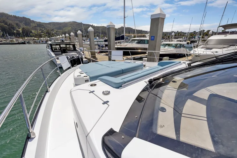 Slide: The Image of Die Cruisers Yachts 57 Fly von 2026 liegt im Hafen. Sie hat ein geräumiges Deck mit blauen Polstern. - 21