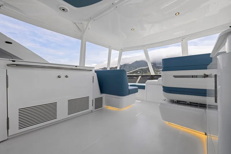 Slide: The Image of Das Bild zeigt das moderne Interieur einer Cruisers Yachts 57 Fly von 2026 mit blauen Sitzen und weißen Oberflächen. - 23