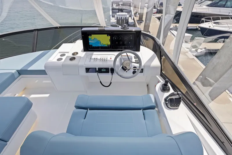 Slide: The Image of Das Bild zeigt das Steuerhaus einer Cruisers Yachts 57 Fly von 2026 mit modernen Instrumenten und blauen Sitzen. - 27
