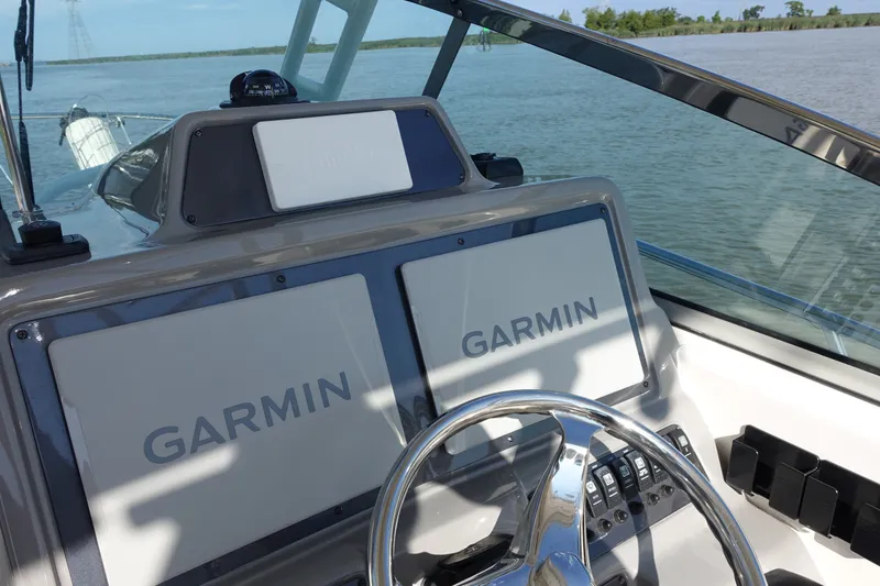 Slide: The Image of 2017 Robalo R305 Walkaround helm with dual Garmin displays on a calm water backdrop. - 19
