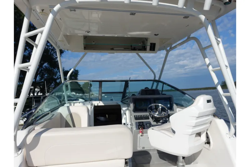 Slide: The Image of 2017 Robalo R305 Walkaround boat cockpit with steering wheel and navigation controls. - 17