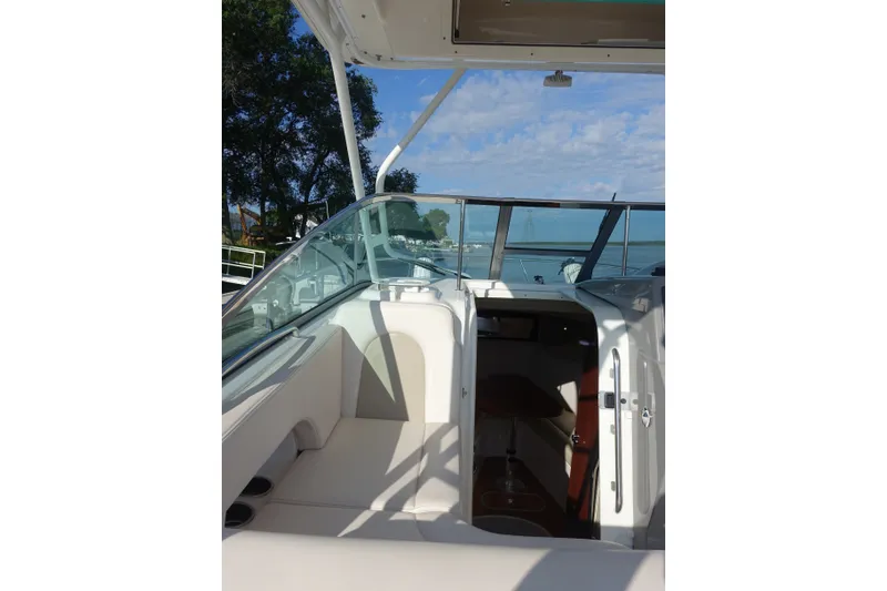 Slide: The Image of 2017 Robalo R305 Walkaround boat interior with open cabin door, showcasing seating and water view. - 24