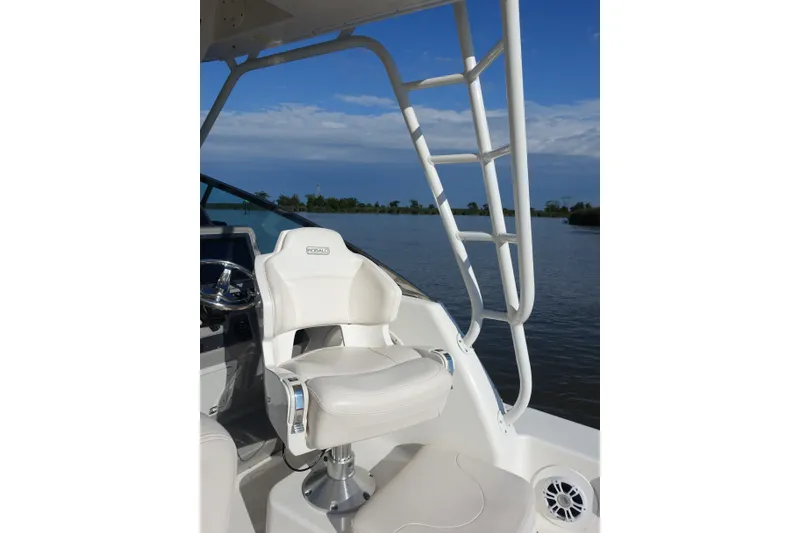 Slide: The Image of 2017 Robalo R305 Walkaround boat interior with white captain's chair and water view. - 22