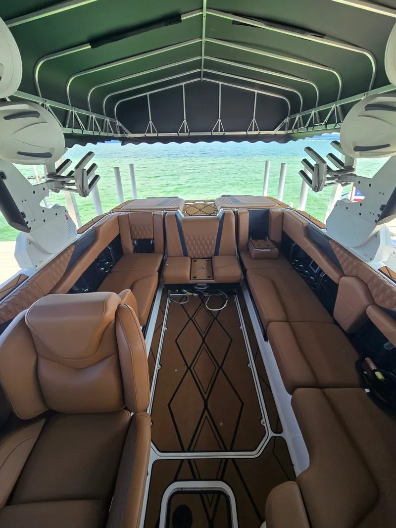 Slide: The Image of The image shows the luxurious interior of a 2024 Malibu M242 boat with brown leather seating. - 5