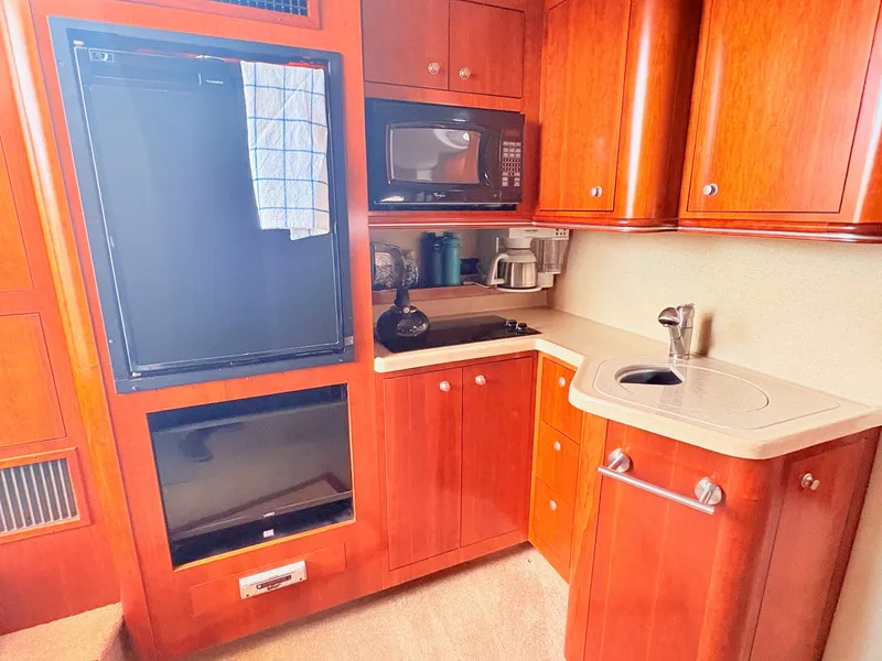 Slide: The Image of The 2007 Cruisers 37O Express galley features wooden cabinets, a sink, and modern appliances. - 25