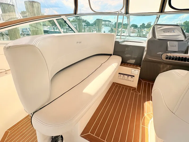 Slide: The Image of The image shows the cockpit of a 2007 Cruisers 37O Express with white seating and wood flooring. - 15